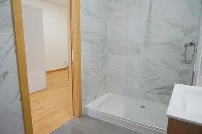 a bathroom with a shower with a tub and a sink at Tomas FLAT Front in Porto