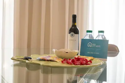 a glass table with a bottle of wine and a plate of food at Cardosas Story Apartments by Porto City Hosts in Porto