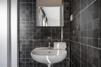 a bathroom with a white sink and a mirror at PortoNest Downtown Studios in Porto