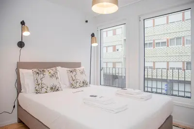 a bedroom with a white bed with a large window at Liiiving in Porto - Modern & Glam Apartment M in Porto