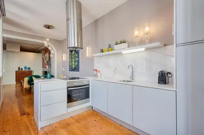 a kitchen with white cabinets and a sink at OPORTO GUEST Luxus Ildefonso in Porto