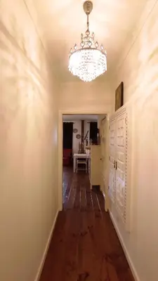 a hallway with a chandelier on the wall and a table at DockApartment in Vila Nova de Gaia
