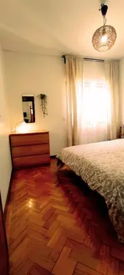 a bedroom with a bed and a dresser and a window at Gulbenkian 39 in Vila Nova de Gaia
