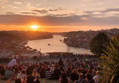 a crowd of people watching a river at sunset at Gulbenkian 39 in Vila Nova de Gaia