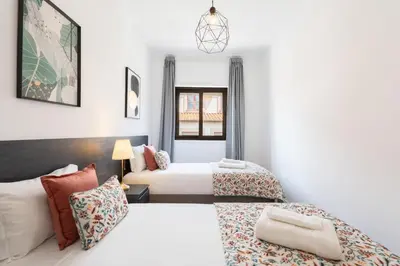 a bedroom with two beds and a couch at Host Wise - Comfy Minimalist Flat in Porto