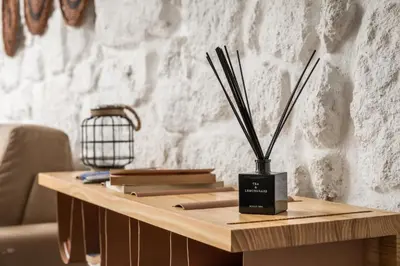 a wooden table with a vase with sticks on it at Clérigos Design by Hosty in Porto