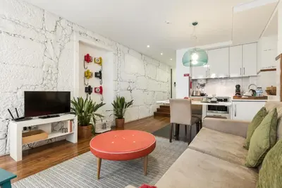 a living room with a couch and a table and a kitchen at Clérigos Design by Hosty in Porto