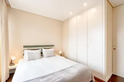 a bedroom with a white bed and white cabinets at VIVA Peaceful Zen Retreat in Porto