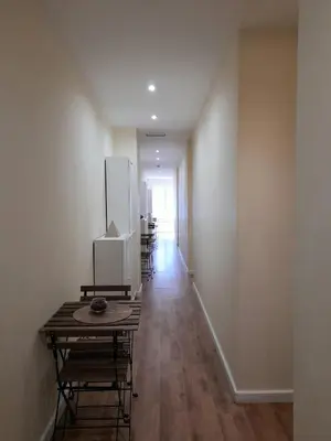 a hallway with chairs and a table in a room at Clérigos Ville Porto Rooms in Porto