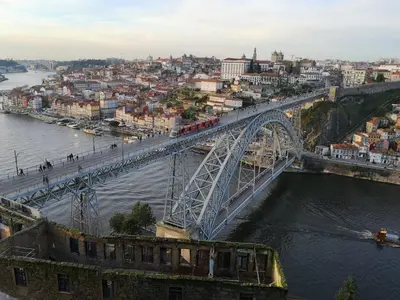 a bridge over a river with a city at Clérigos Ville Porto Rooms in Porto