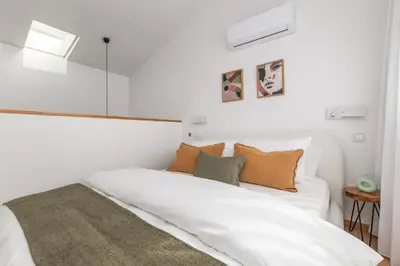 a bedroom with a white bed with orange pillows at Urban Loft in Porto