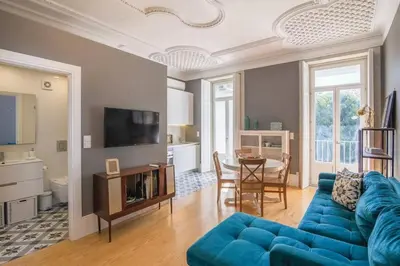 a living room with a blue couch and a table at Central location with balcony & equipped kitchen in Porto