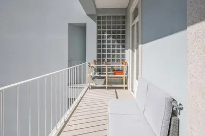 a balcony with a bench on the side of a building at Central location with balcony & equipped kitchen in Porto