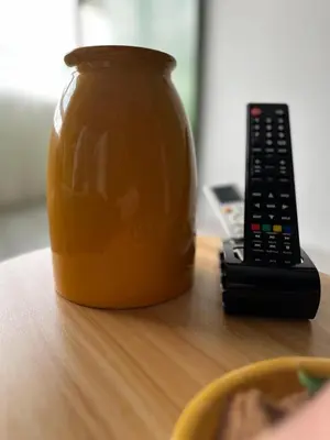 a jar of honey and a remote control on a table at Porto Charme Residence in Porto