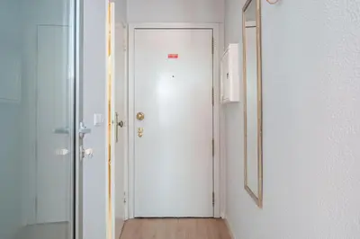 a hallway with a white door and a mirror at Marquês Studio by Amber Star Rent in Porto