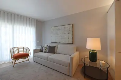 a living room with a couch and a chair at FLH Boavista Woody Flats in Porto