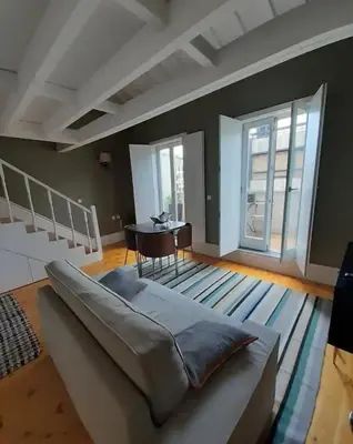 a living room with a large bed and a table at Mezzanine in Porto