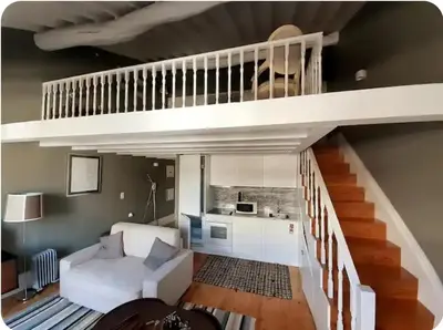 a living room with a white couch and a staircase at Mezzanine in Porto