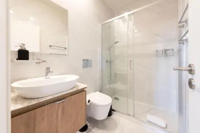 a white bathroom with a sink and a shower at Chic Porto Hideaway: Pool & Garden in Porto
