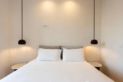 a bedroom with a large white bed with two pillows at Chic Porto Hideaway: Pool & Garden in Porto