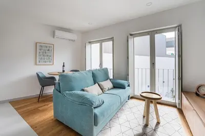 a living room with a blue couch and a table at GuestReady - Downtown Refuge with Private Parking in Porto