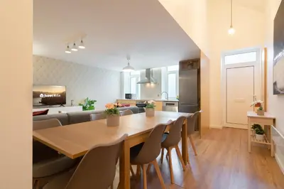 a kitchen and living room with a wooden table and chairs at Host Wise - Central Duplex House - Terrace in Vila Nova de Gaia