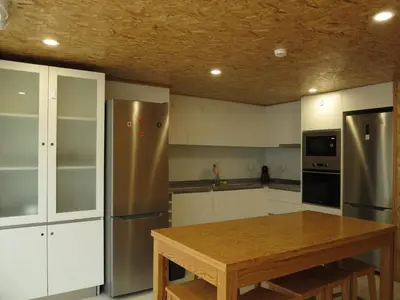a kitchen with a wooden table and a stainless steel refrigerator at Porto Encanto- 7 Bedrooms in Porto