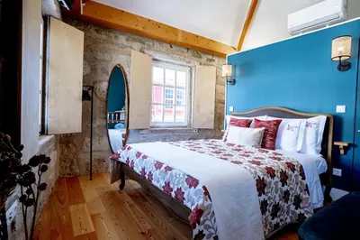a bedroom with a bed with a blue wall at Authentic Porto Suites in Porto