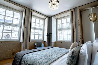 a bedroom with a large bed and windows at Authentic Porto Suites in Porto