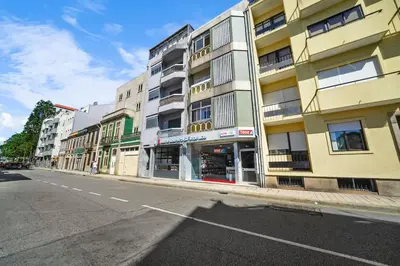an empty street in front of a tall building at Apartamento D' Alegria in Porto