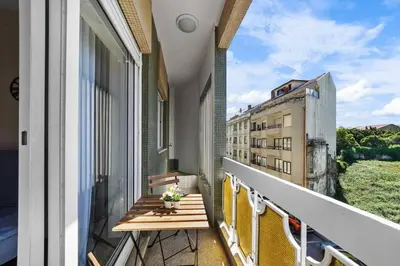 a balcony with a table and a view of a building at Apartamento D' Alegria in Porto