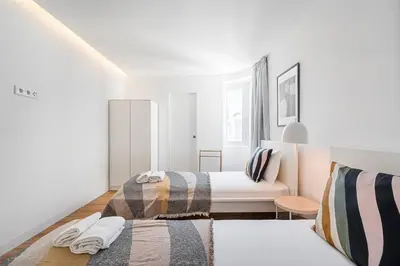 a white room with two beds and a couch at GuestReady - Relaxing moment in a vibrant city in Porto