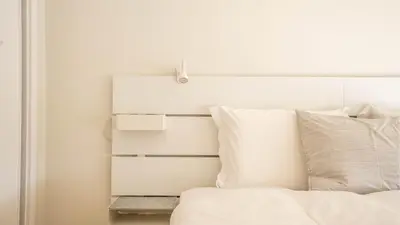 a bed with a white headboard and pillows at Capelo Residency by LovelyStay in Porto
