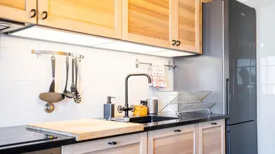 a kitchen with wooden cabinets and a sink at Capelo Residency by LovelyStay in Porto