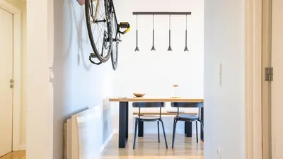 a dining room with a table and a bike hanging on the wall at Capelo Residency by LovelyStay in Porto