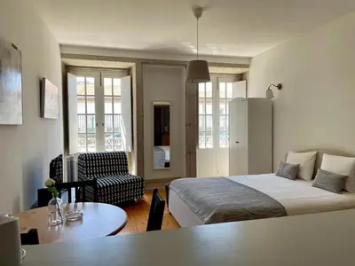 a bedroom with a bed and a chair and a table at Douro River Cozy Flats in Porto