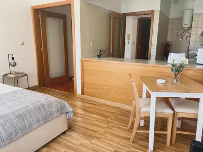 a bedroom with a bed and a table and a kitchen at Douro River Cozy Flats in Porto