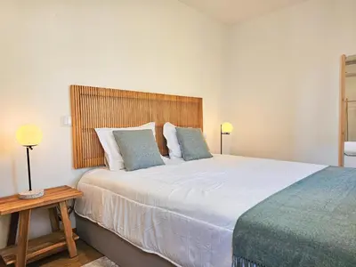 a bedroom with a large bed with a wooden headboard at VIVA Boho House Duplex in Porto