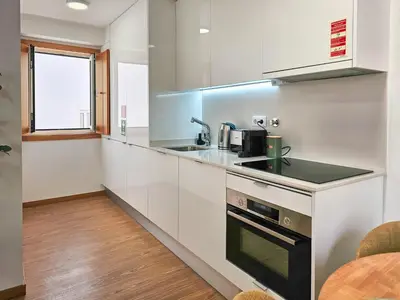 a kitchen with white cabinets and a sink at VIVA Boho House Duplex in Porto