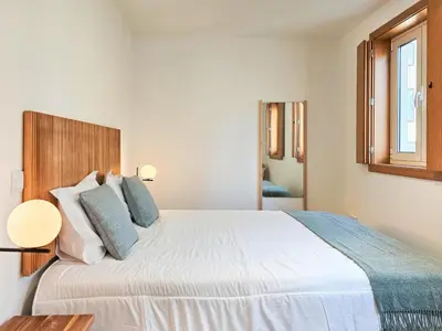 a bedroom with a large white bed with blue pillows at VIVA Boho House Duplex in Porto