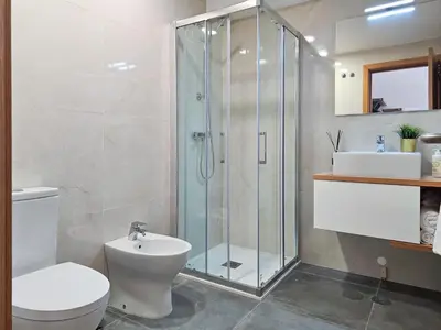 a bathroom with a shower and a toilet and a sink at VIVA Boho House Duplex in Porto