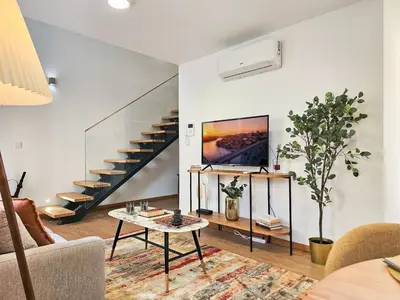 a living room with a staircase and a table at VIVA Boho House Duplex in Porto