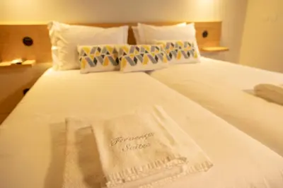 a hotel room with a bed with a towel on it at Fervença Suites in Vila Nova de Gaia