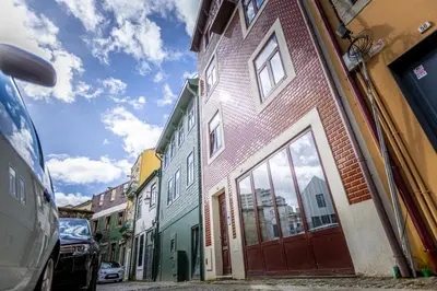 a narrow street with colorful buildings on the side at Fervença Suites in Vila Nova de Gaia