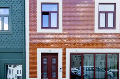a brick building with three windows and two doors at Fervença Suites in Vila Nova de Gaia