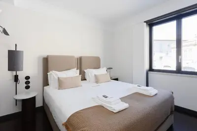 a bedroom with a large white bed with a window at Liiiving in Porto - Casa Duque Apartments in Porto