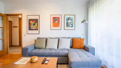 a living room with a blue couch and a table at Infante Cozy 1BR w Parking by LovelyStay in Vila Nova de Gaia