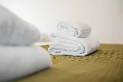 a stack of white towels sitting on a bed at GuestReady - Modern Home In Gaia in Vila Nova de Gaia