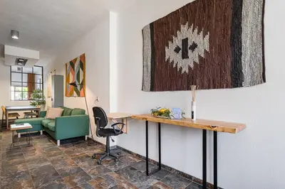 a living room with a table and a green couch at GuestReady - Modern Home In Gaia in Vila Nova de Gaia