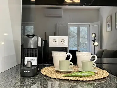 a kitchen counter with two cups and a coffee maker at The Green House - Oporto Charming Apartment in Porto